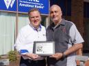 ARRL Chief Executive Officer David Minster, NA2AA (left) presents the 2021 ARRL Technical Innovation Award plaque for Wojciech Kaczmarski, SP5WWP, to Ed Wilson, N2XDD, the M17 Project Community Manager, at ARRL Headquarters. [Alex Norstrom, KC1RMO, photo]